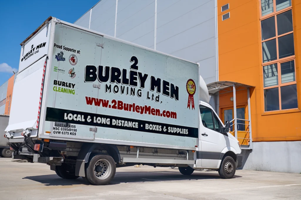 2 Burley Men Moving van parked in front of a commercial building.