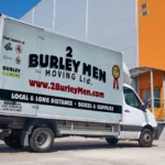 2 Burley Men Moving van parked in front of a commercial building.